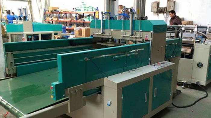 Multiple fully automatic bag making machines arranged in a production line with single supervisor monitoring for high-volume vest bag manufacturing